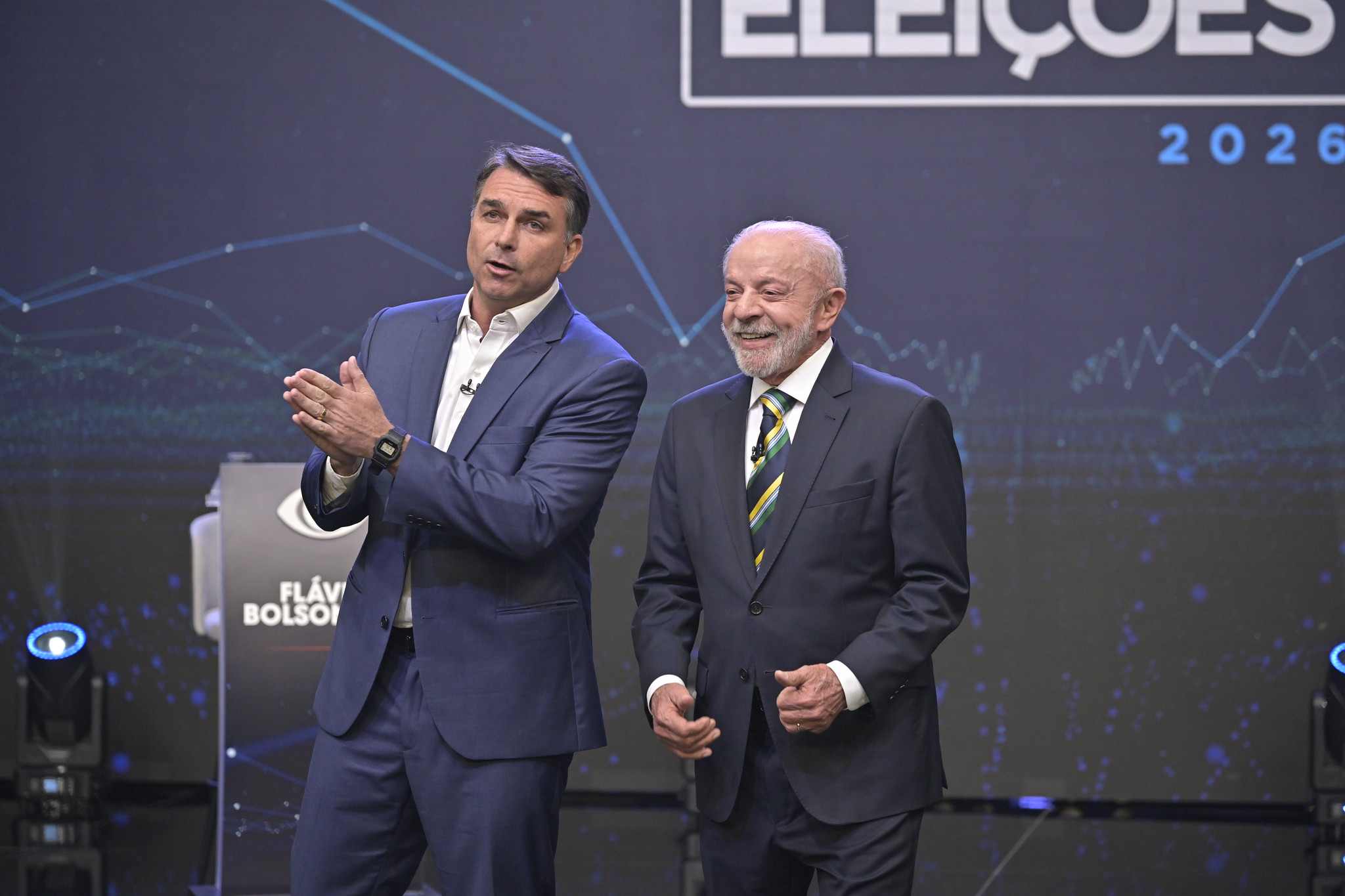 Acessórios de Lula e Flávio Bolsonaro geram contraste em debate